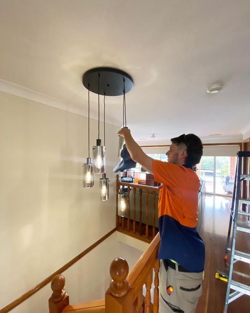 JBT electrician installing a pendant cluster