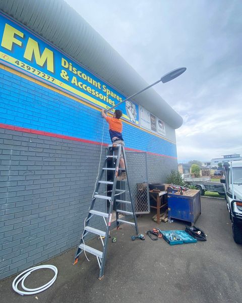 JBT electrician installing commercial exterior lighting on a retail unit